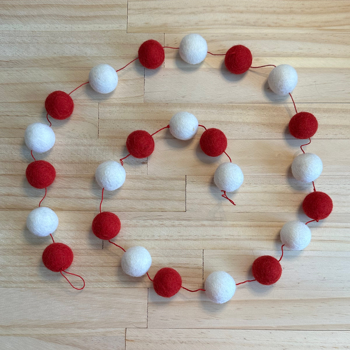 Red and White Wool balls strung on red string measuring 4ft. 