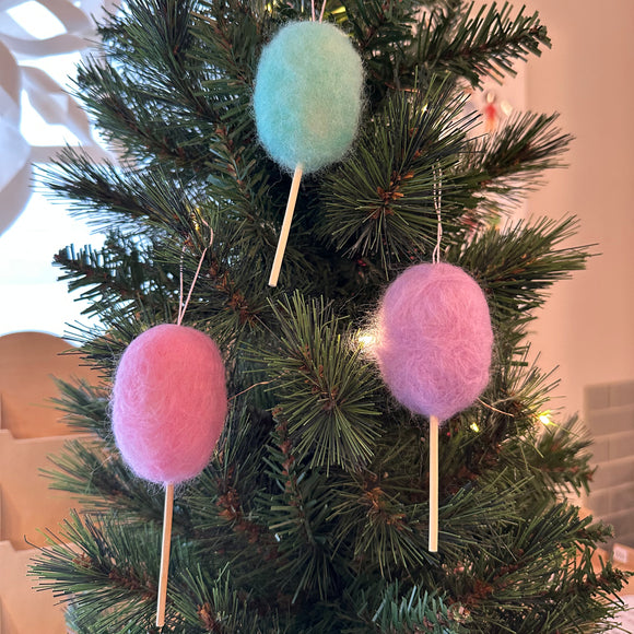 Three colorful felted cotton candy ornaments against a gray background